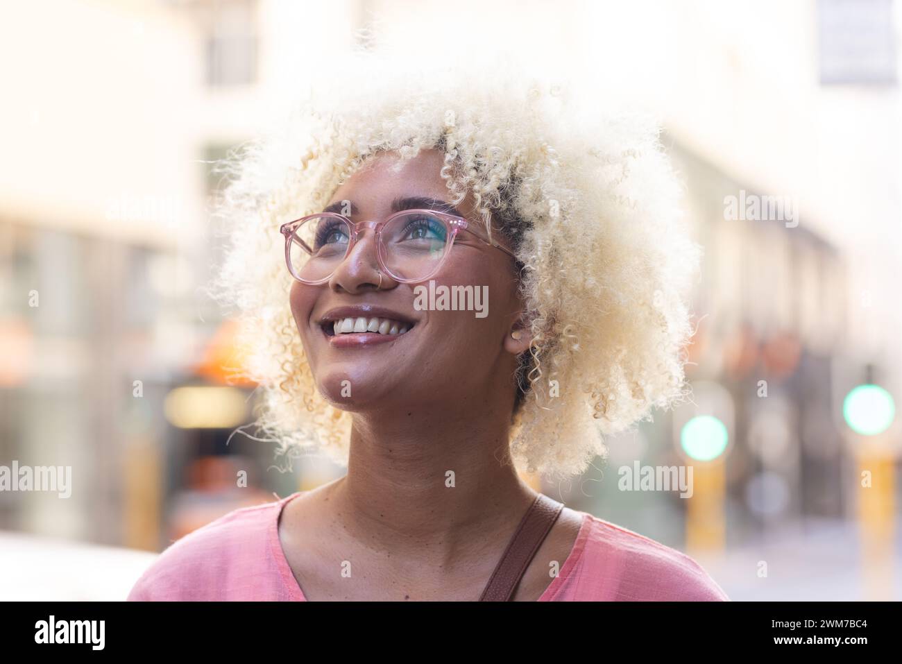 Young biracial woman smiles brightly in the city Stock Photo