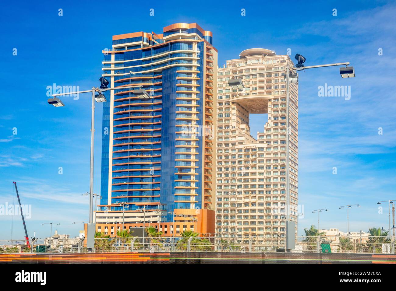 Residential and business buildings at the corniche with race track street lights in the foreground, Jeddah, Saudi Arabia Stock Photo
