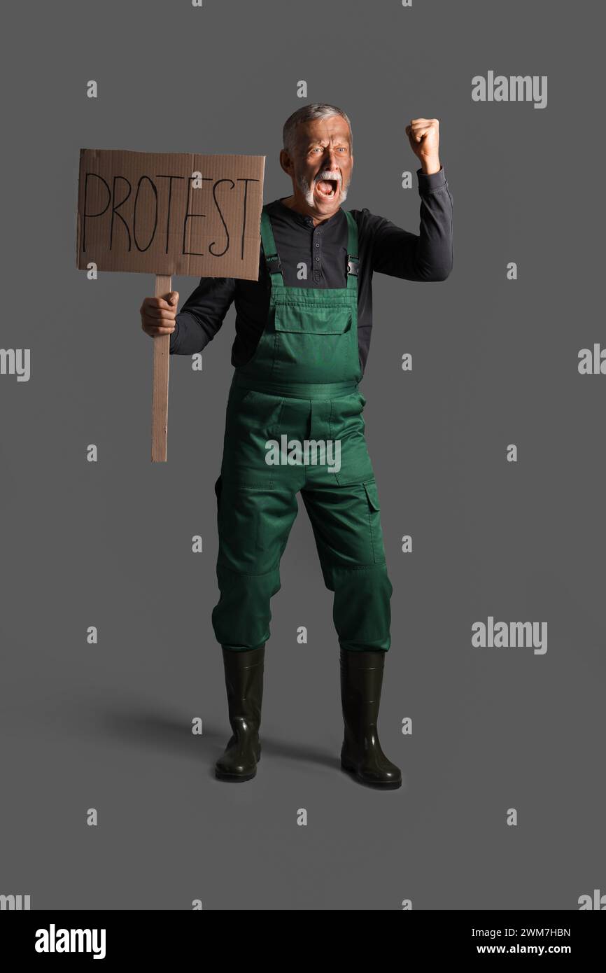 Protesting miner man with placard on dark background Stock Photo
