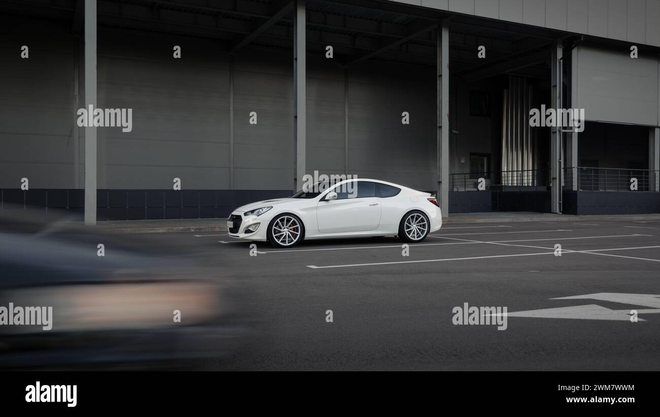 white Hyundai Genesis Coupe parked near grey warehouse wall. Front ...