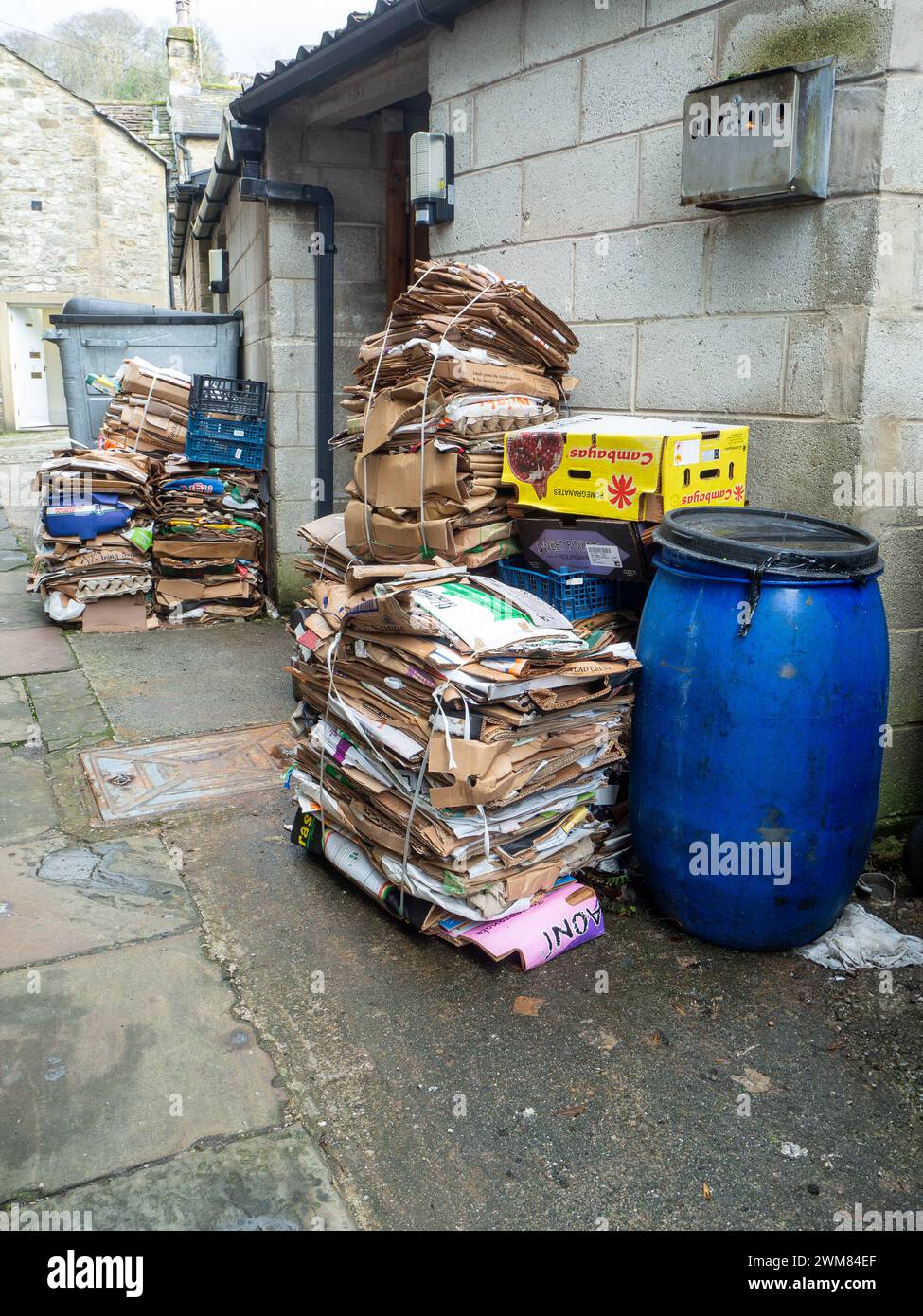Cardboard waste bales left outside a business premises to be collected for recycling. Stock Photo