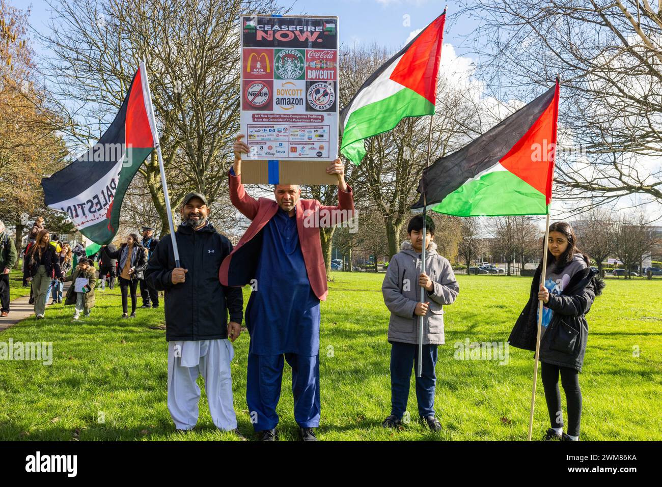 Bradford, UK. 24 FEB, 2024.  Demonstrators hold Palestinian flags and a list of companies to boycott at start of West Yorkshire for Palestine March. Gipsy ST/Leeds RD. Credit Milo Chandler/Alamy Live News Stock Photo