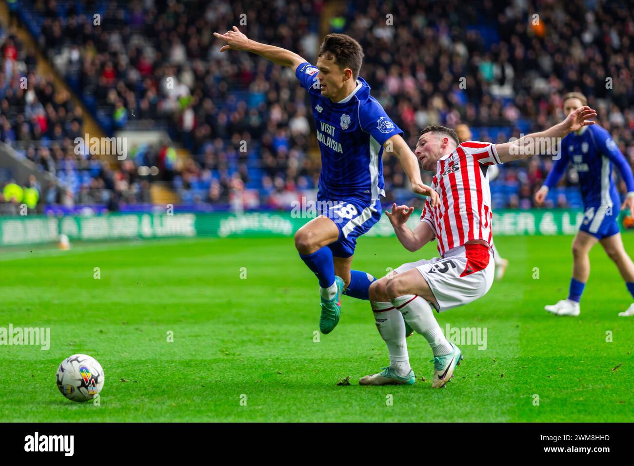 Cardiff, UK. 24th Feb, 2024. Perry Ng of Cardiff City is tackled by Jordan Thompson of Stoke City during the EFL Skybet championship match, Cardiff City v Stoke City at the Cardiff City Stadium in Cardiff, Wales on Saturday 24th February 2024. This image may only be used for Editorial purposes. Editorial use only, pic by Credit: Andrew Orchard sports photography/Alamy Live News Stock Photo