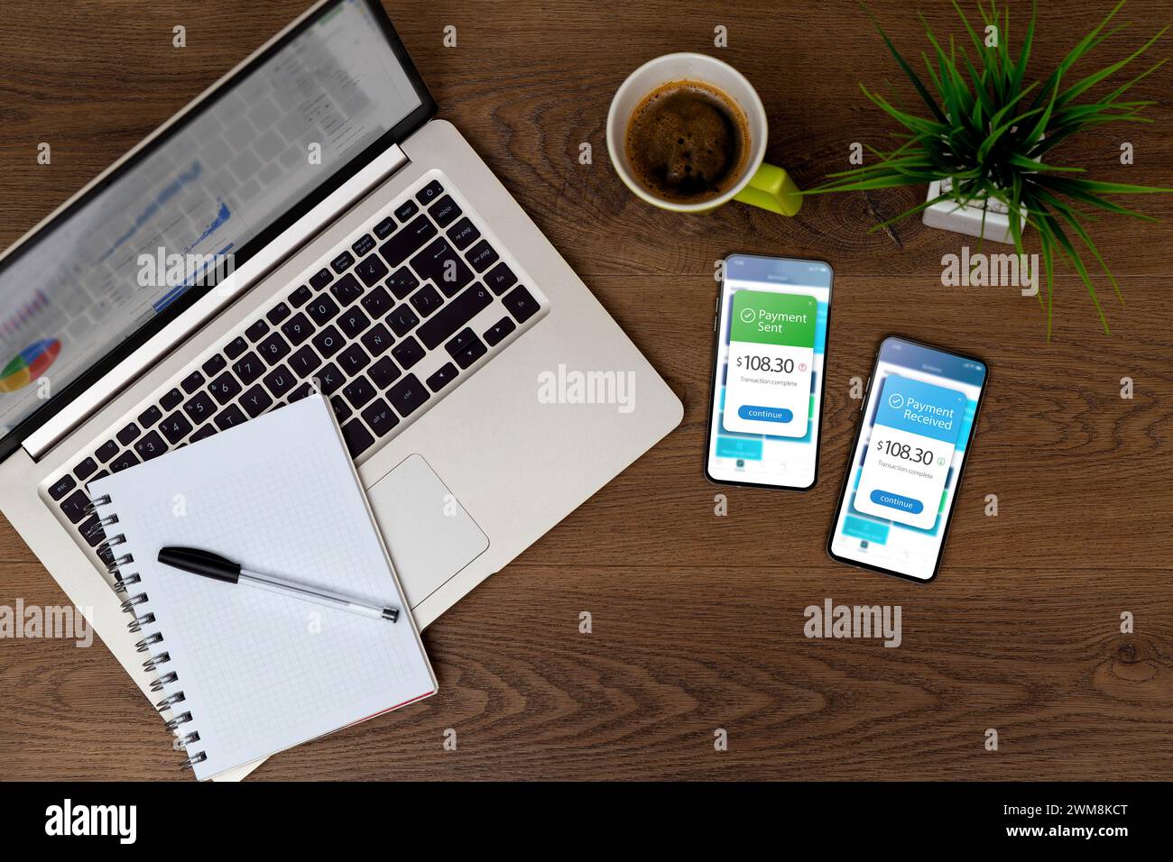 Two smartphones over the desktop showing sending and receiving payments through a digital wallet application on a mobile phone. Bank transfer concept. Stock Photo