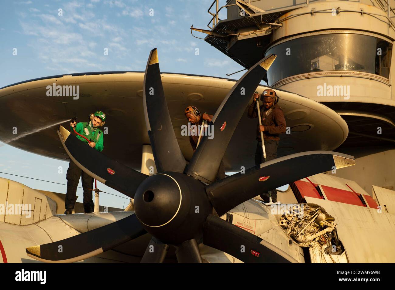 240129-N-GJ011-1100 RED SEA (Jan. 29, 2024) Sailors clean an E-2C ...