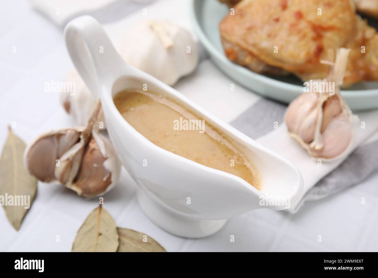 Delicious turkey gravy in sauce boat on white table, closeup Stock Photo