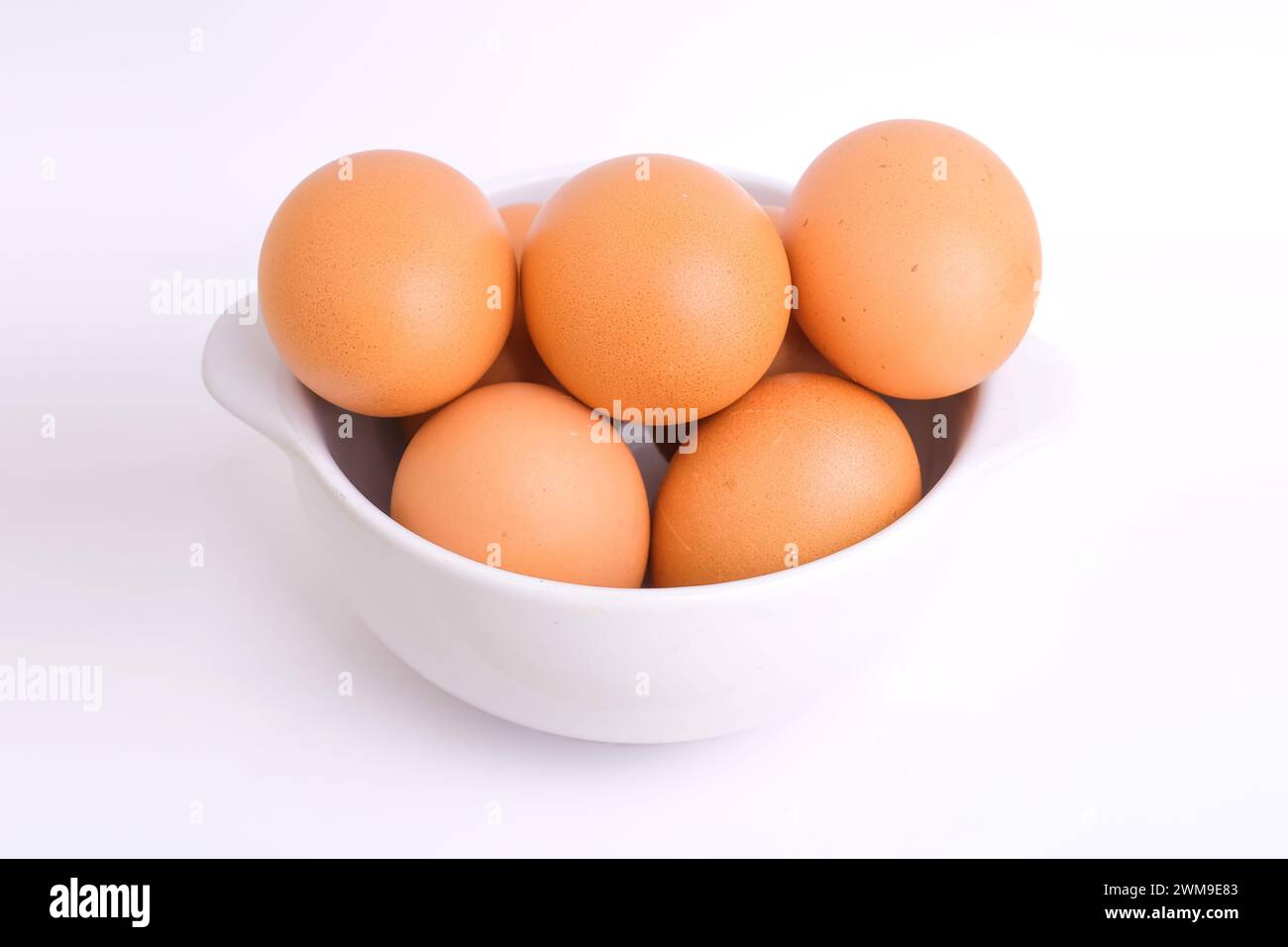 Fresh chicken eggs in a white bowl on a white background Stock Photo