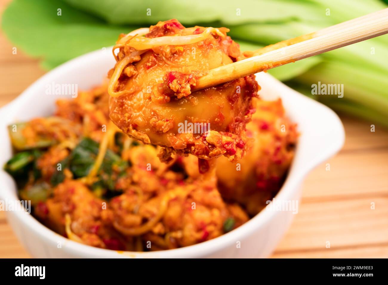 Fried dumplings in a white bowl. Made from wet dumplings that are sauteed with mustard greens, bean sprouts and spicy seasonings Stock Photo