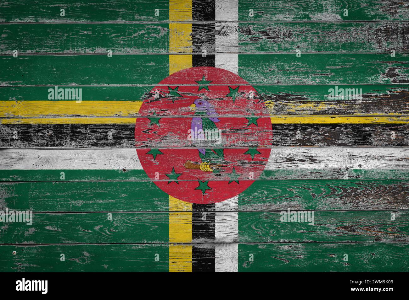 The national flag of Dominica is painted on uneven wooden boards ...
