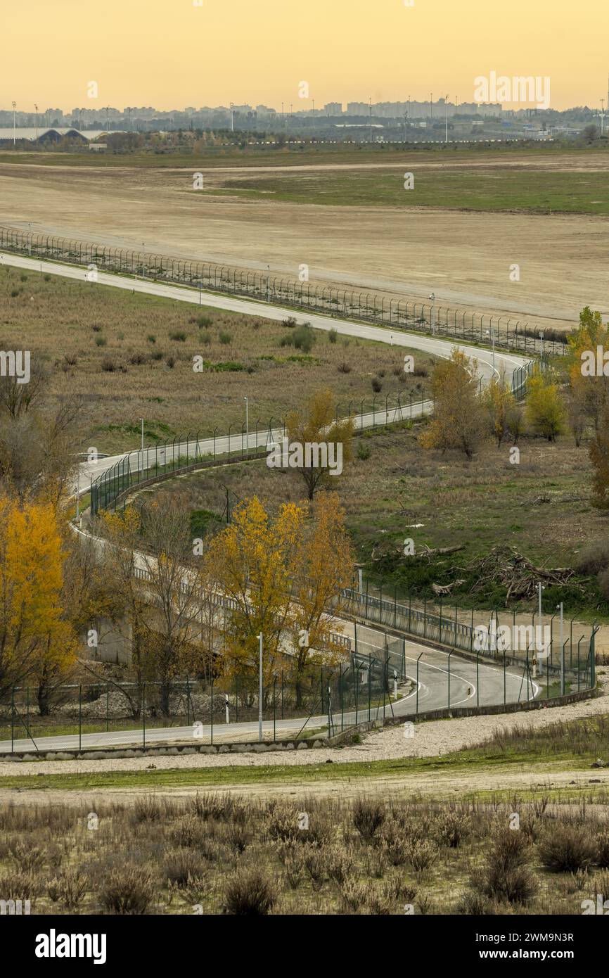Curves on an interior maintenance road in a facility with security perimeter fence Stock Photo