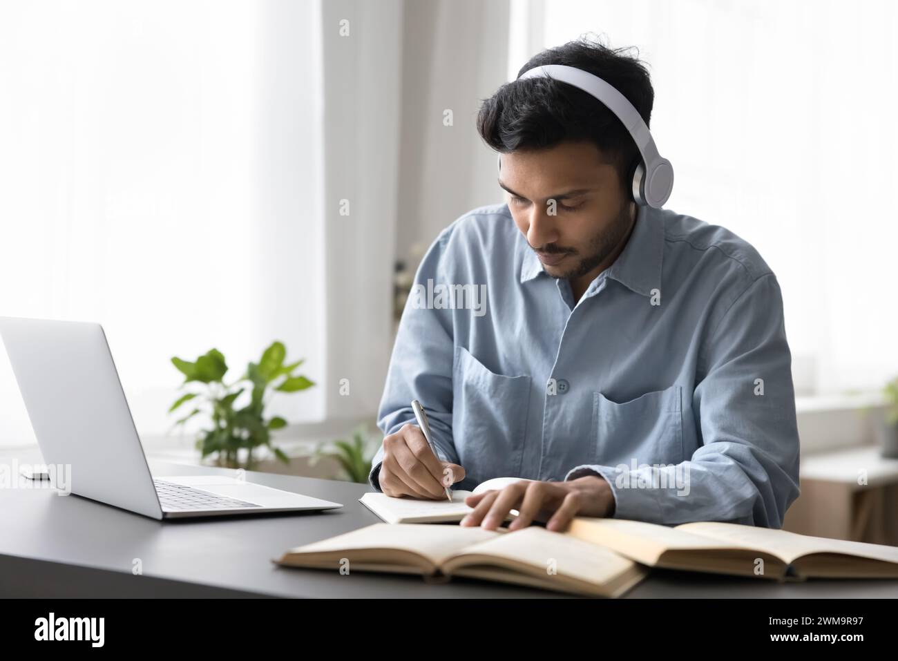 Young Indian man studying on-line using laptop Stock Photo