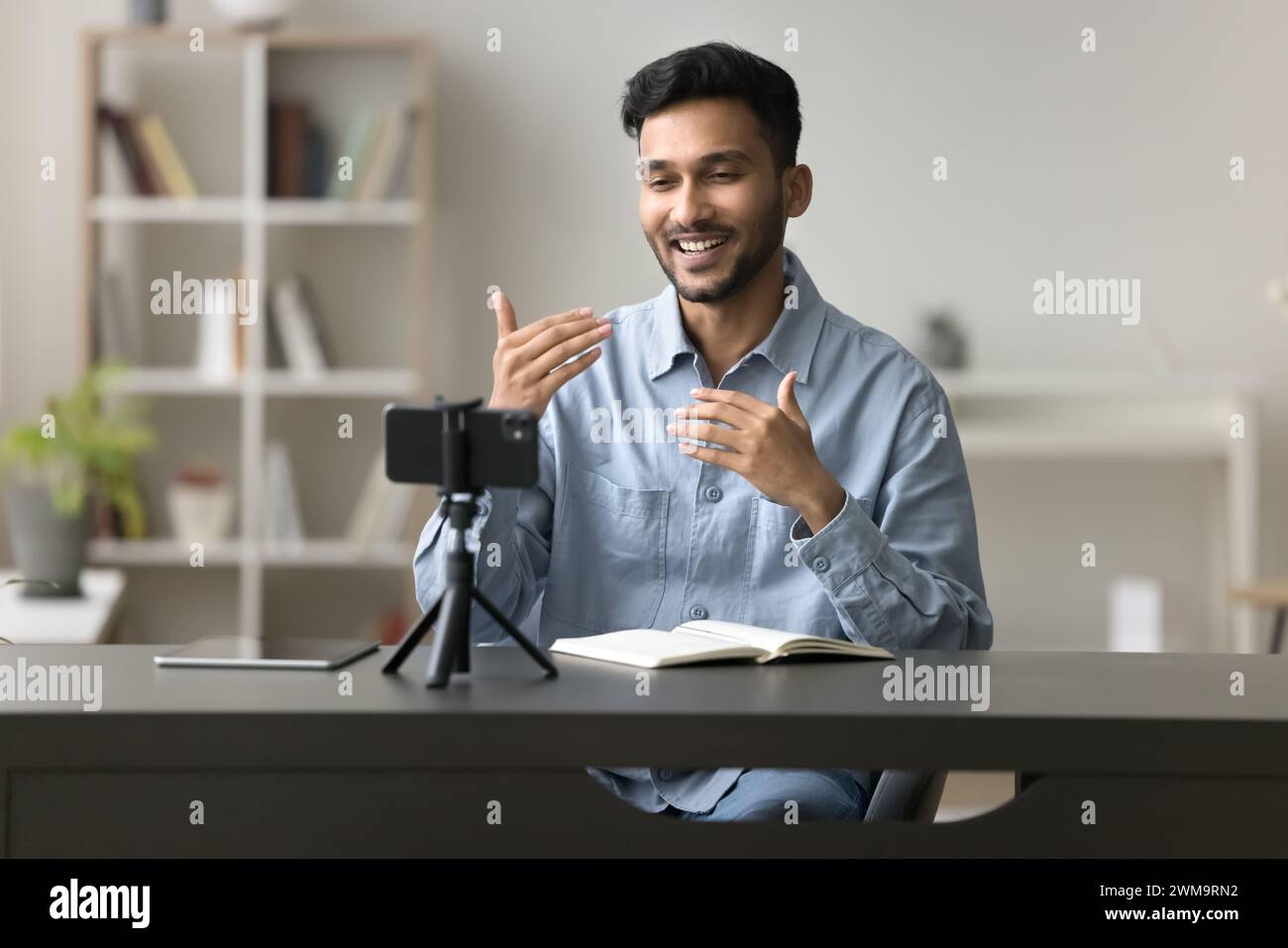 Male blogger make speech on smartphone camera, stand on tripod Stock Photo
