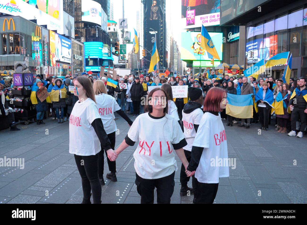 Pro-Ukraine demonstrators, each wearing a t-shirt with a name of a Ukrainian city written on it, rally in Times Square. Demonstrators rallied in Manhattan, New York City on the two-year anniversary of the Russian invasion of Ukraine. Protestors condemned the invasion and opposed Russian President, Vladimir Putin. Last weekend, Russian forces captured the eastern Ukrainian city of Avdiivka located on the front line. The loss of the city comes as a $60 billion aid package for Ukraine from the United States has been stalled following disagreements in Congress. Ukrainian President, Volodymyr Zelen Stock Photo