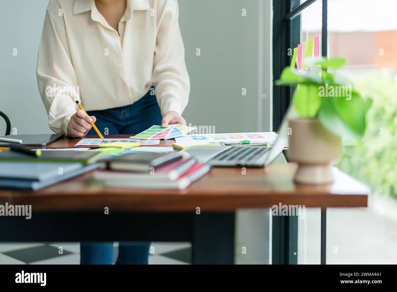 Creative graphic designer holding color sample and comparing color ...