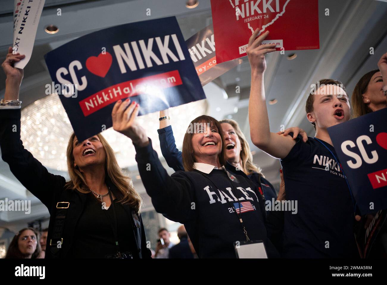 People celebrate as updated poll numbers are shown during Republican