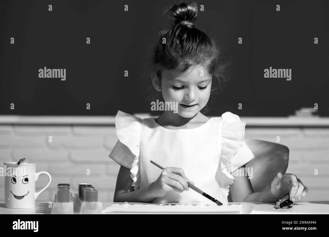 Little girls drawing a colorful pictures with pencil crayons in school