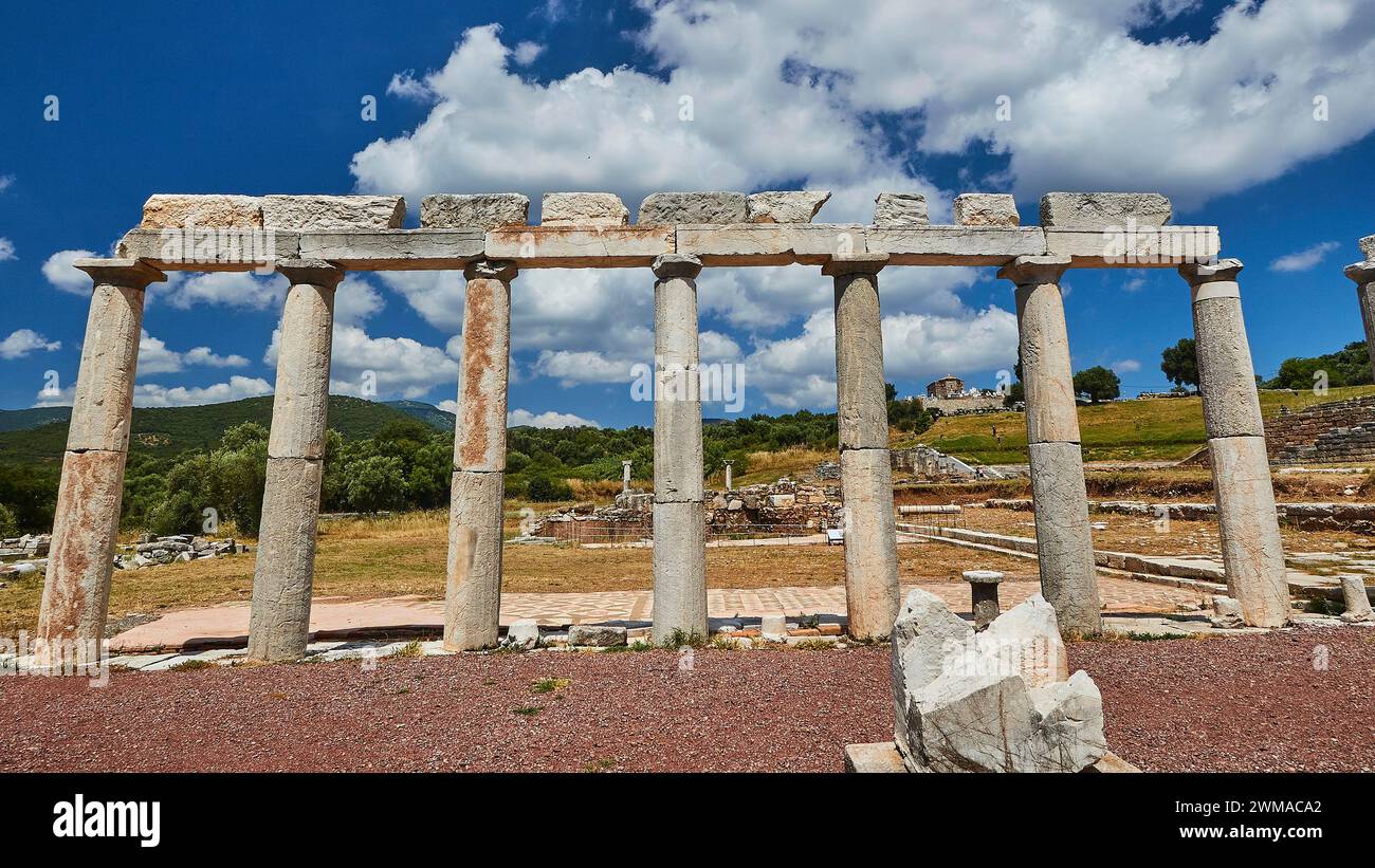 Ruins of ancient columns under a blue sky with fluffy clouds, Stoa of ...