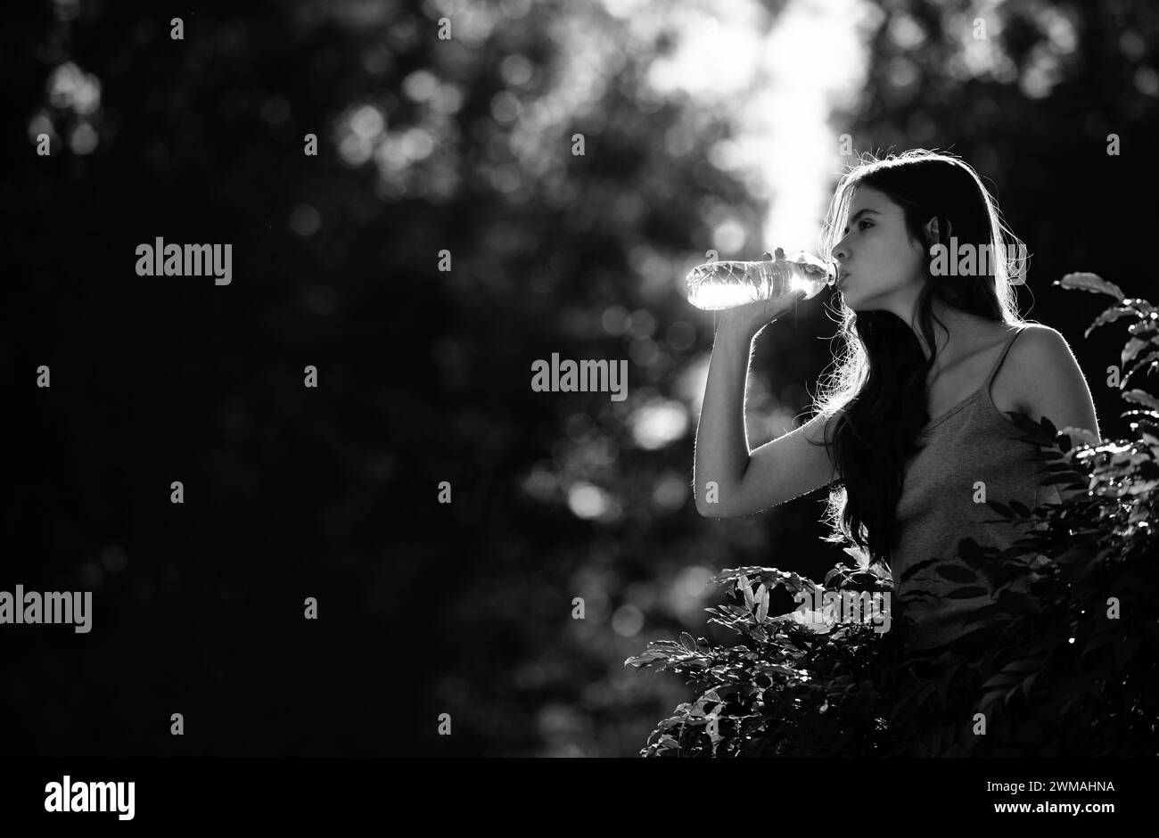 Healthy woman drinking water from bottle outdoor. Stay hydration concept. Unhidrated. Unity with nature, Stock Photo