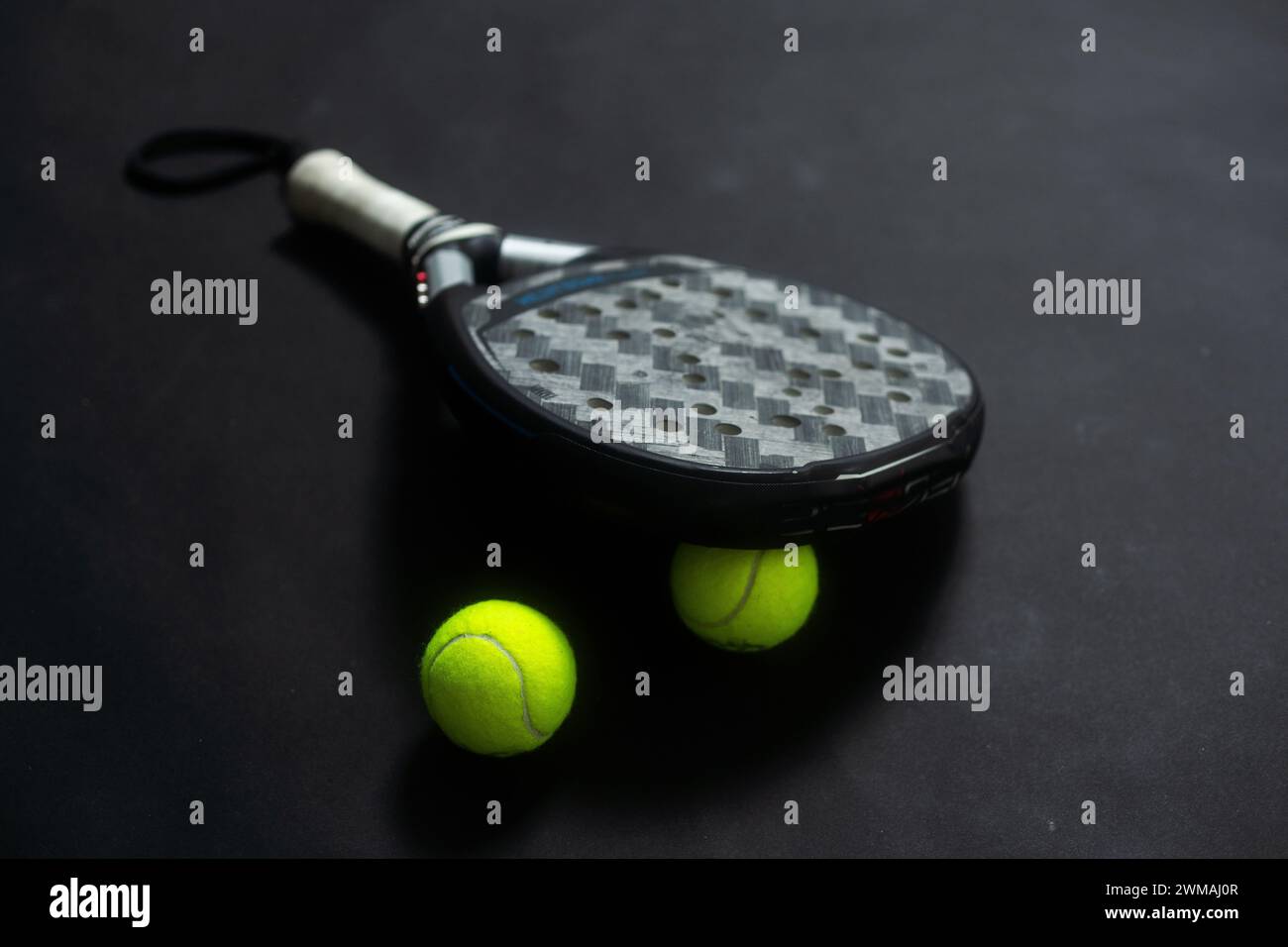 Detailed background of black and white padel racket and ball on black ...