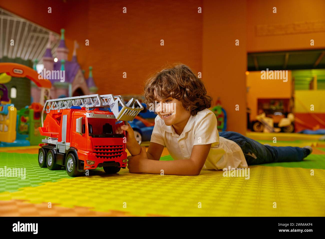 Boy child playing vehicle toys at kids care center Stock Photo - Alamy