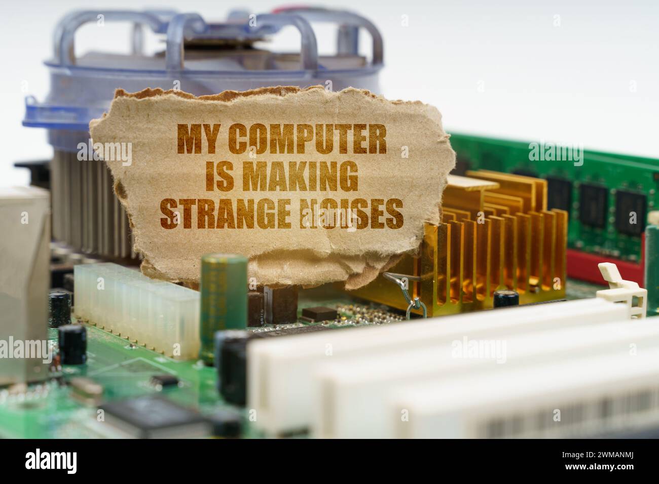 On the computer motherboard there is a cardboard with the inscription - My computer is making strange noises. Computer repair concept. Stock Photo