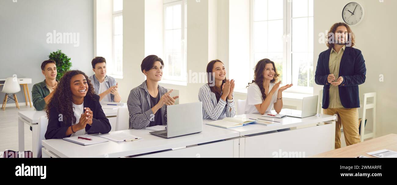 Joyful excited college students applaud after successful lecture by teacher.  Stock Photo