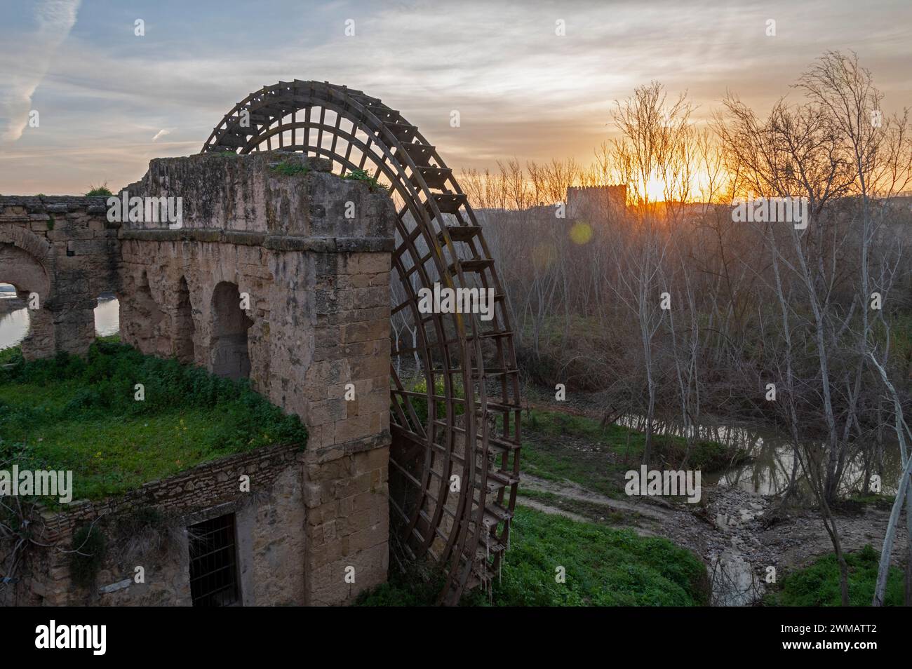 The Sun rises over a large disused medieval wooden structured water wheel known as the Molino de la Albolafia on the banks of the Guadalquivir river Stock Photo