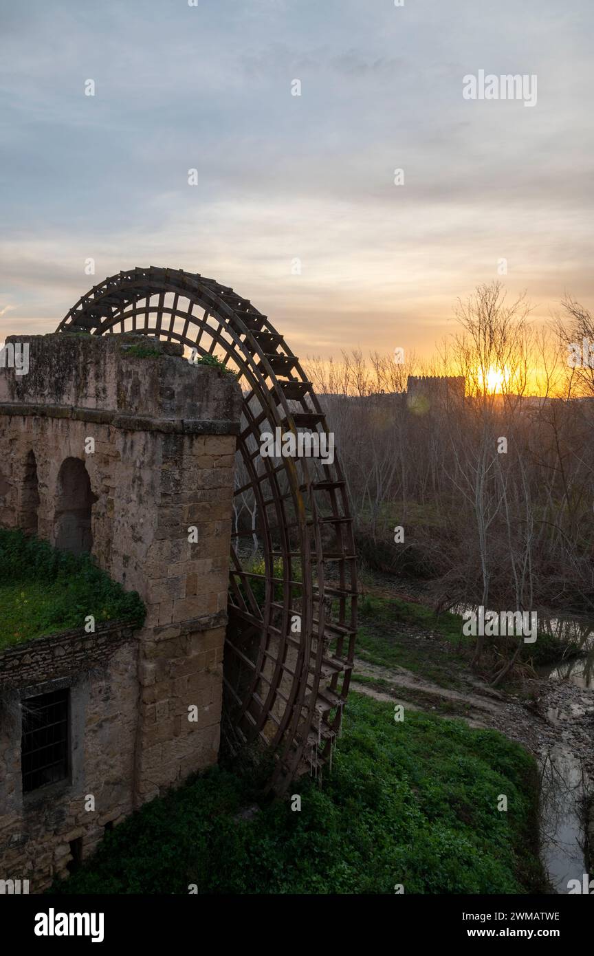 The Sun rises over a large disused medieval wooden structured water wheel known as the Molino de la Albolafia on the banks of the Guadalquivir river Stock Photo