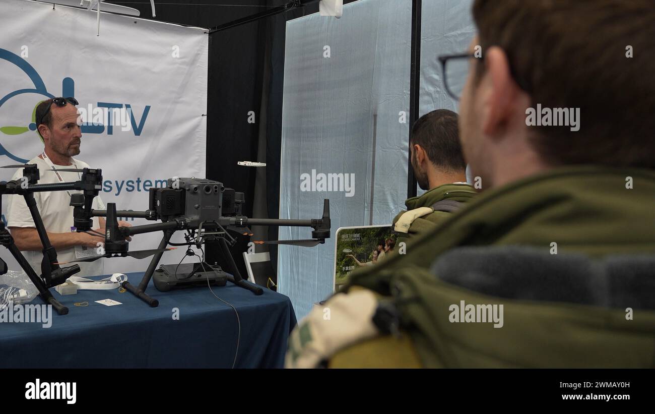 A representative of a drone company presents a pocket-sized self-flying camera to Israeli soldiers at the Dronetech event, showcasing an extensive array of innovative technologies in the field of Unmanned Aerial Vehicles. on February 22, 2024 in Tel Aviv, Israel. Stock Photo