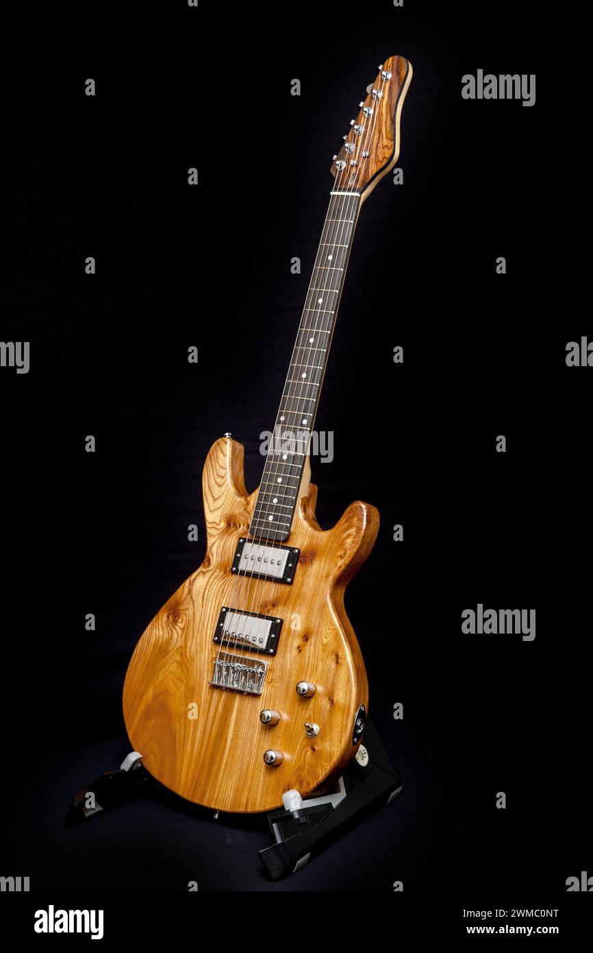 Hand built electric guitar made of elm wood. Hand made guitar. Elm tree wood, elm timber. Hardtail bridge, humbucker pickups, short scale 24' inch Stock Photo