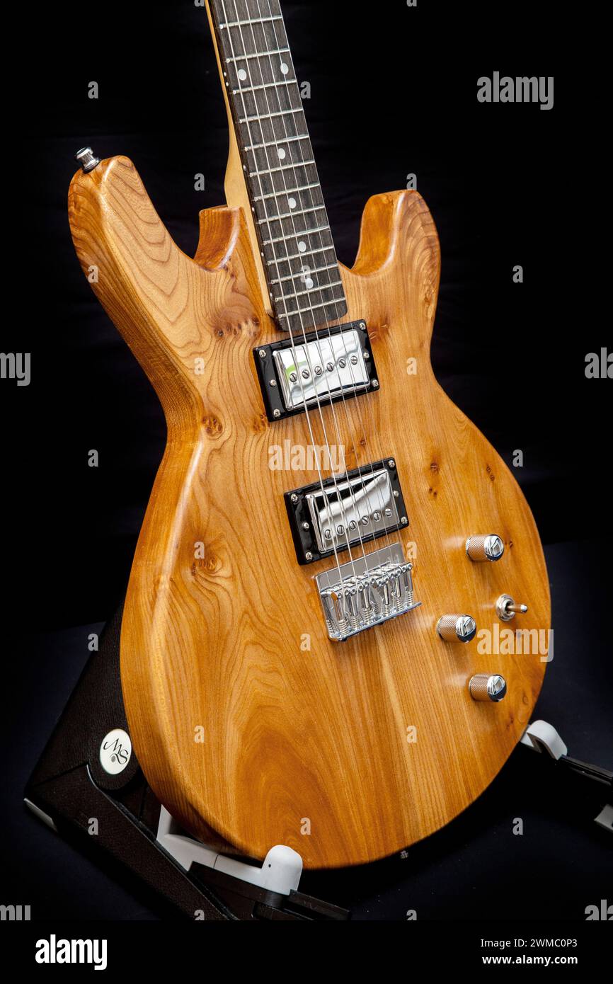 Hand built electric guitar made of elm wood. Hand made guitar. Elm tree wood, elm timber. Hardtail bridge, humbucker pickups, short scale 24' inch Stock Photo