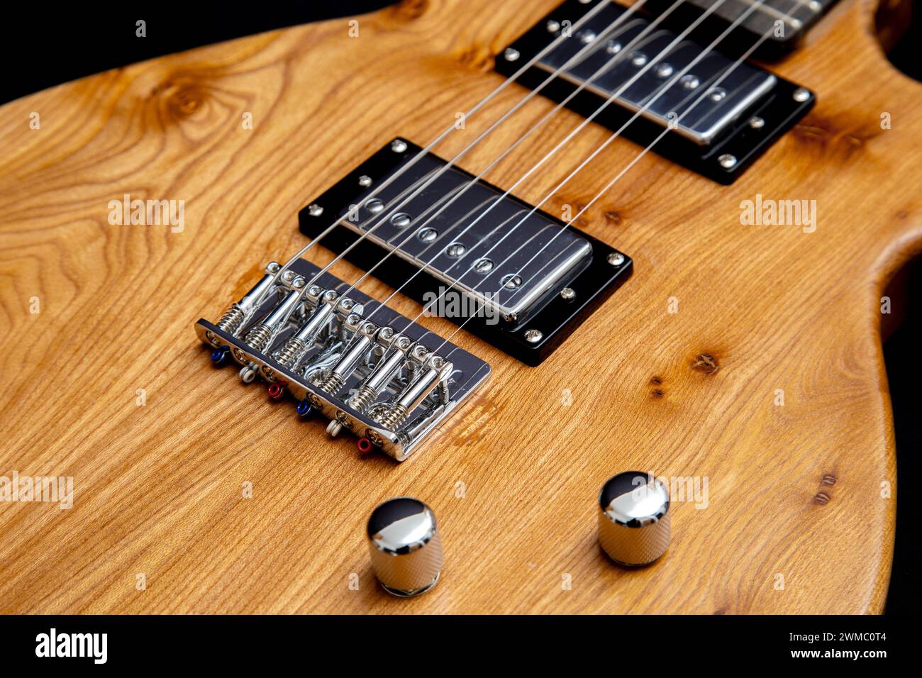 Hand built electric guitar made of elm wood. Hand made guitar. Elm tree wood, elm timber. Hardtail bridge, humbucker pickups, short scale 24' inch Stock Photo