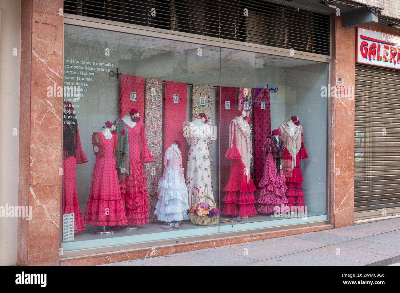 A Flamenco dress shop in Cordoba in Andalusia, southern Spain.  The Flamenco dress worn by women, is a traditional Spanish dress with body-hugging to Stock Photo