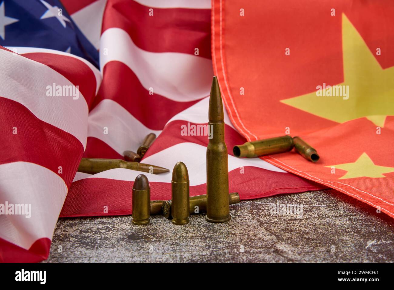 Ammunition rounds placed on the flag of the United States and China Stock Photo