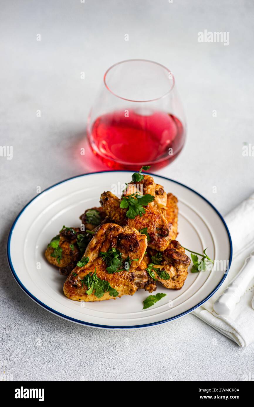 Close-up of Roasted chicken wings with coriander and a fruit drink Stock Photo