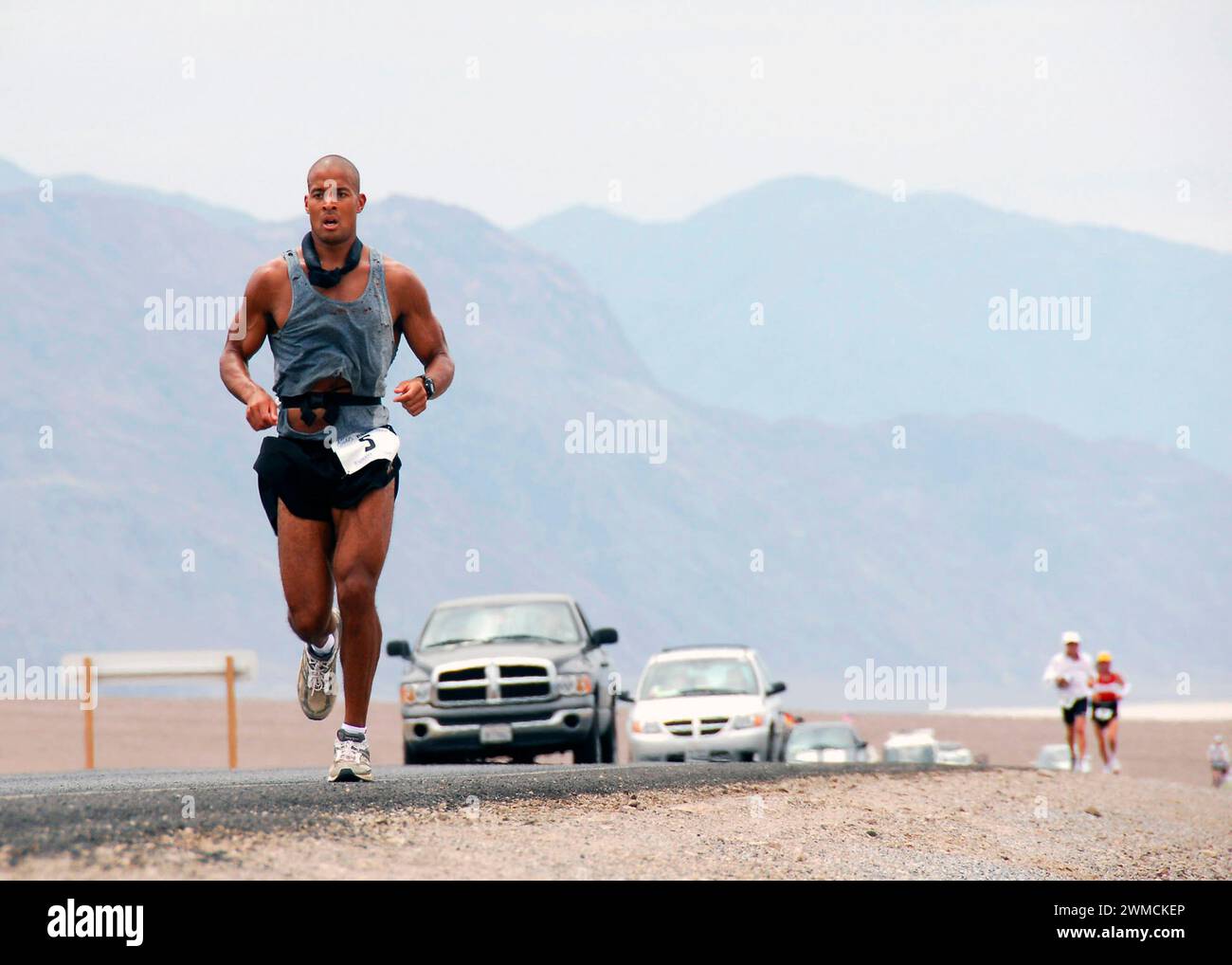 Death Valley, United States of America. 23 July, 2007. U.S Navy Special Warfare Operator 1st Class David Goggins, left, keeps up the pace as he runs 135 miles through scorching Death Valley National Park during the Badwater Ultramarathon, July 23, 2007 in Death Valley, California. Goggins finished the race in third place after 25 hours of running from the lowest point in the USA to the highest point. Credit: MCS Brandon Rogers/US Navy Photo/Alamy Live News Stock Photo