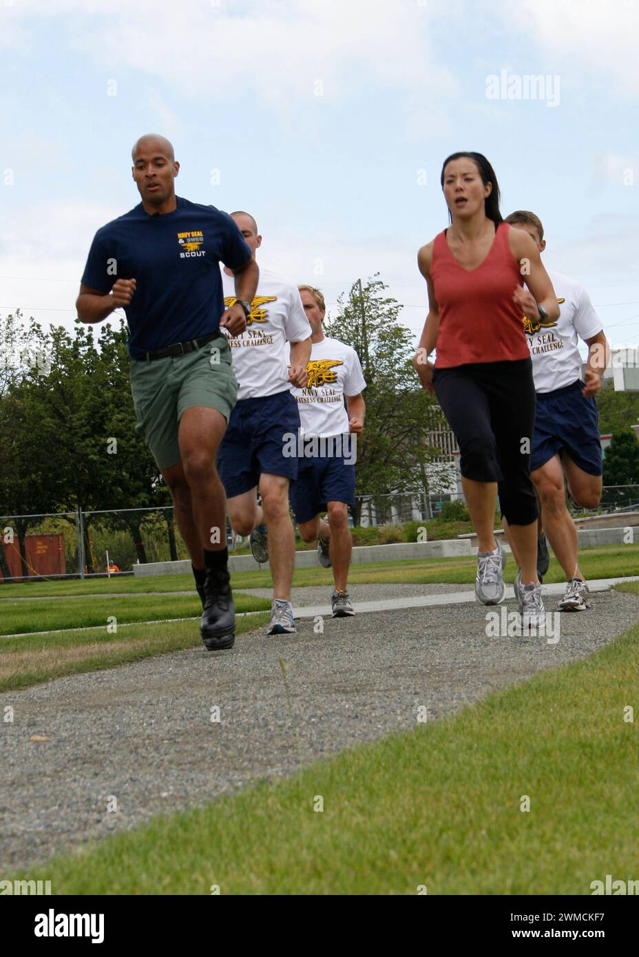 Seattle, United States of America. 07 July, 2009. U.S Navy Special Warfare Operator 1st Class David Goggins, left, runs alongside Q13 Fox TV news anchor Lara Yamada, right, to promote the upcoming Navy SEAL Fitness Challenge, July 7, 2009 in Seattle, Washington. Googins is know as the “Toughest Man Alive” from his extreme sports exploits.  Credit: MC2 Michelle Kapica/US Navy Photo/Alamy Live News Stock Photo