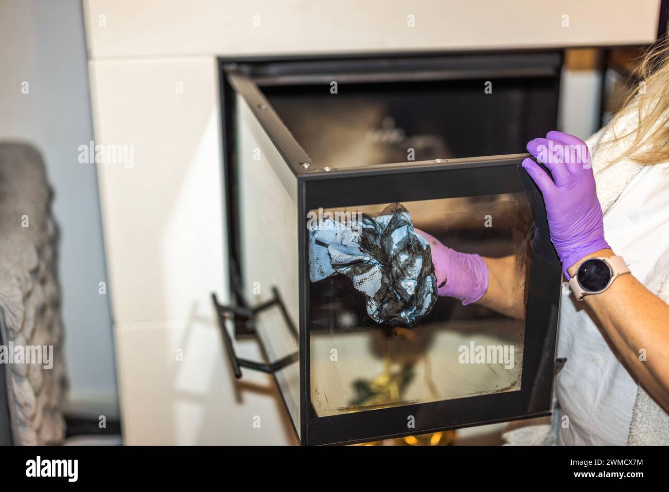 Closeup view of woman cleaning soot from the glass door of the