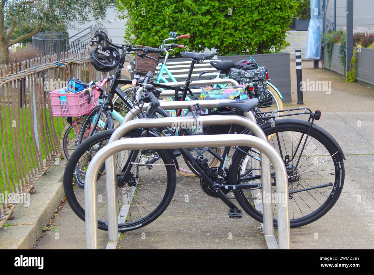 Dublin, Ireland - Februar 24th 2024: A photo of several bicycles parked alongside a metal bike rack on a path in a park in Dublin. Stock Photo