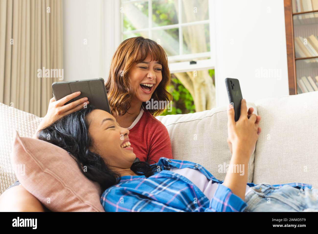 Two women enjoy a fun moment together at home Stock Photo