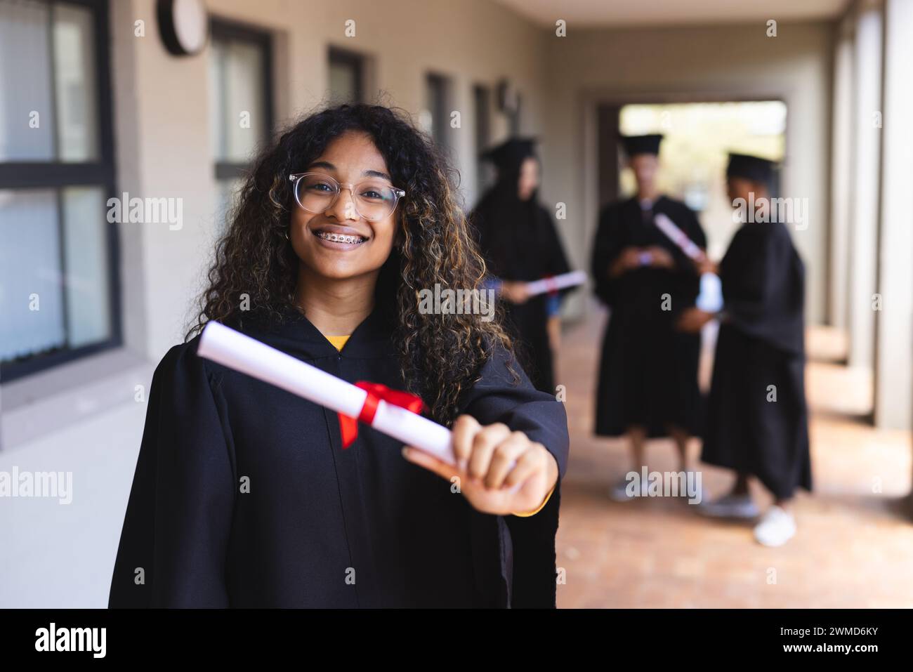 Teenage biracial girl proudly displays her diploma at graduation Stock ...