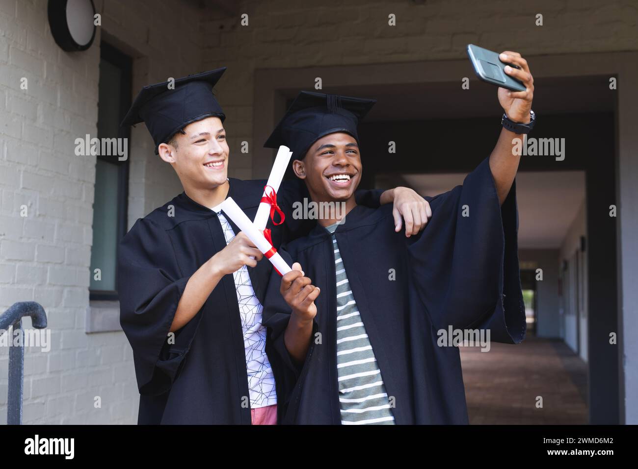Biracial teenage boys celebrate graduation Stock Photo