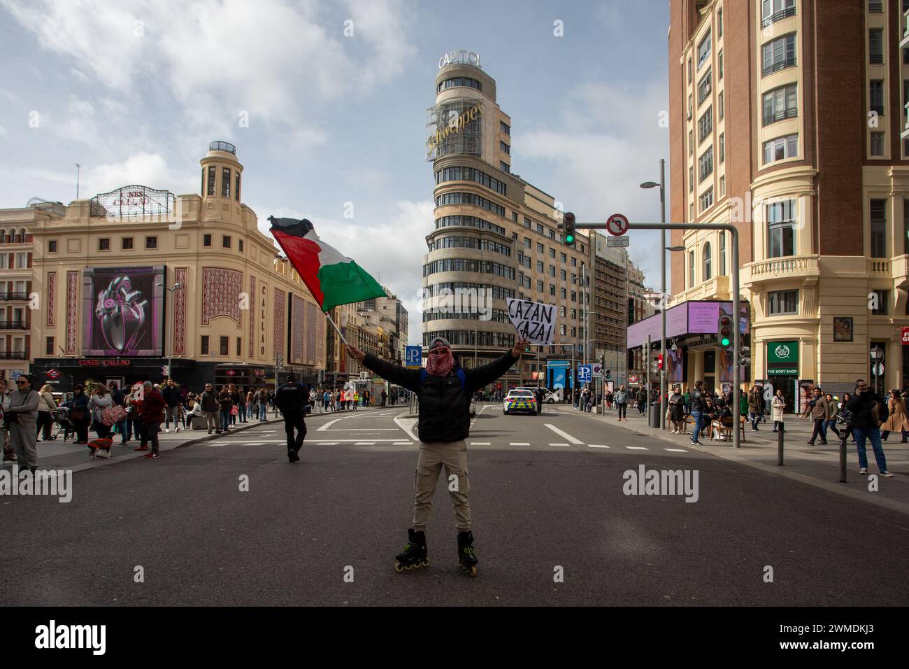 Madrid, Spain. 25th Feb, 2024. A protester poses in the middle of Madrid's Gran Via while holding a Palestinian flag and placard during the pro-Palestinian demonstration. Thousands of people demonstrated on Sunday, February 25, in the center of Madrid to demand a ceasefire by the state of Israel against the Palestinian people as well as an end to the sale of weapons by the Spain to the State of Israel. (Photo by David Canales/SOPA Images/Sipa USA) Credit: Sipa USA/Alamy Live News Stock Photo