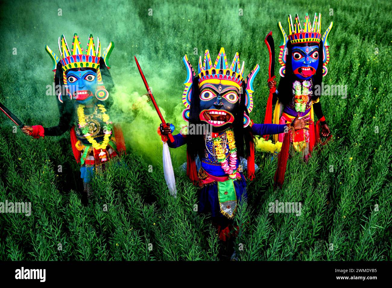 Masked dancers of Gomira dance troupe perform at a big rice field at a village near Raiganj. Gomira is a masked dance form. The word ‘Gomira' has been derived from the colloquial form of the word ‘Gram-Chandi' or the female deity who is the protective force of the village. The exact origin of the dance form is not traceable and the knowledge has been lost over time. Gomira dance is a rural dance form mainly practiced in the Dinajpur district of West Bengal. The Gomira dances are organized to appease the deity to usher in the 'good forces' and drive out the 'evil forces'. It is usually organise Stock Photo