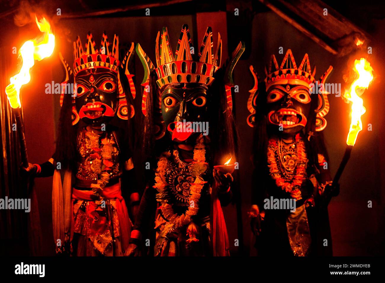 Masked dancers of Gomira dance troupe hold burning torches during the performance. Gomira is a masked dance form. The word ‘Gomira' has been derived from the colloquial form of the word ‘Gram-Chandi' or the female deity who is the protective force of the village. The exact origin of the dance form is not traceable and the knowledge has been lost over time. Gomira dance is a rural dance form mainly practiced in the Dinajpur district of West Bengal. The Gomira dances are organized to appease the deity to usher in the 'good forces' and drive out the 'evil forces'. It is usually organised during m Stock Photo