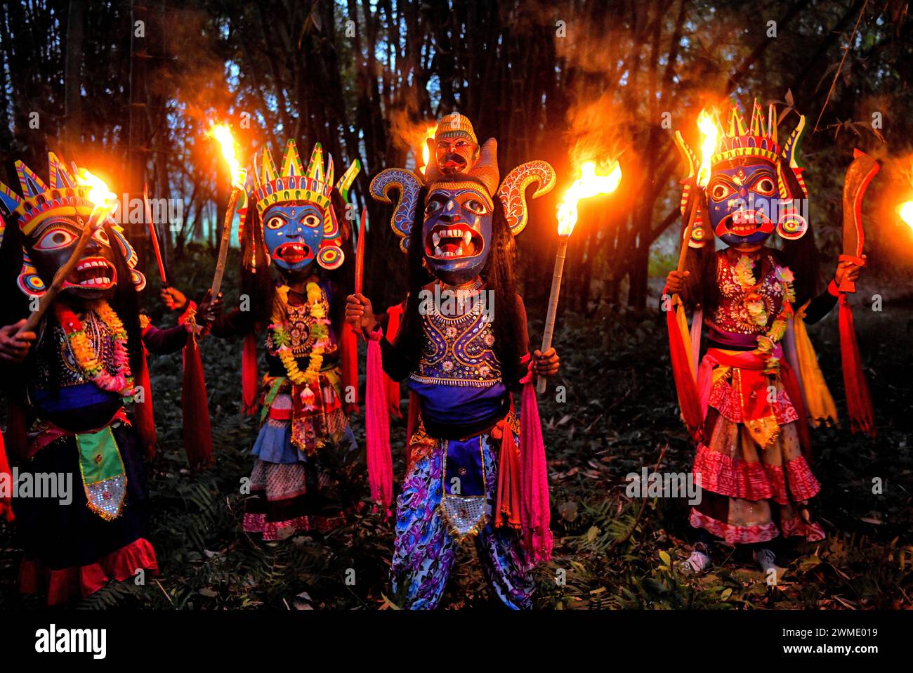 Masked dancers of Gomira dance troupe hold burning torches during the performance. Gomira is a masked dance form. The word ‘Gomira' has been derived from the colloquial form of the word ‘Gram-Chandi' or the female deity who is the protective force of the village. The exact origin of the dance form is not traceable and the knowledge has been lost over time. Gomira dance is a rural dance form mainly practiced in the Dinajpur district of West Bengal. The Gomira dances are organized to appease the deity to usher in the 'good forces' and drive out the 'evil forces'. It is usually organised during m Stock Photo