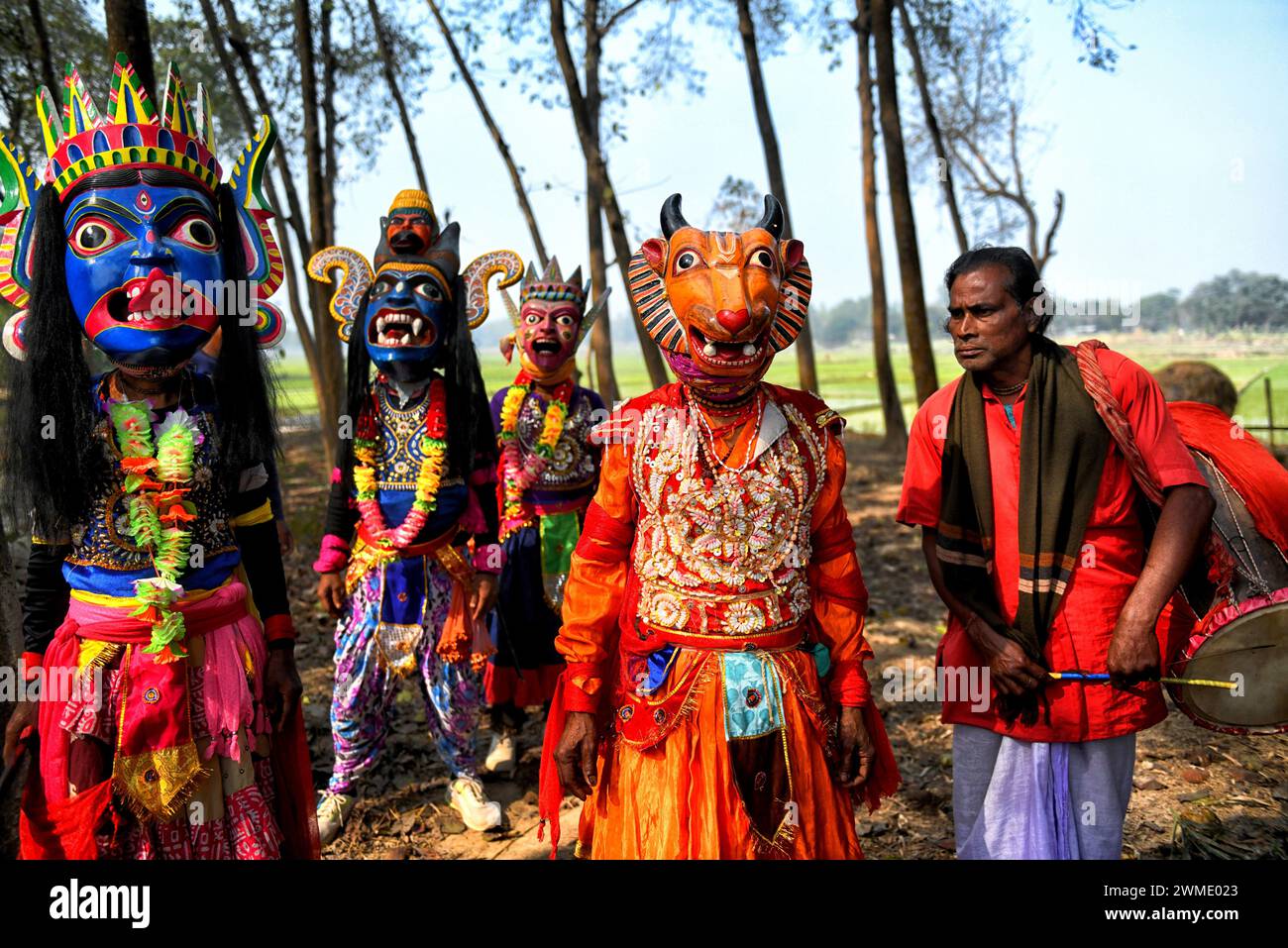 Masked dancers of Gomira dance troupe prepare themselves before their performance at a village. Gomira is a masked dance form. The word ‘Gomira' has been derived from the colloquial form of the word ‘Gram-Chandi' or the female deity who is the protective force of the village. The exact origin of the dance form is not traceable and the knowledge has been lost over time. Gomira dance is a rural dance form mainly practiced in the Dinajpur district of West Bengal. The Gomira dances are organized to appease the deity to usher in the 'good forces' and drive out the 'evil forces'. It is usually organ Stock Photo