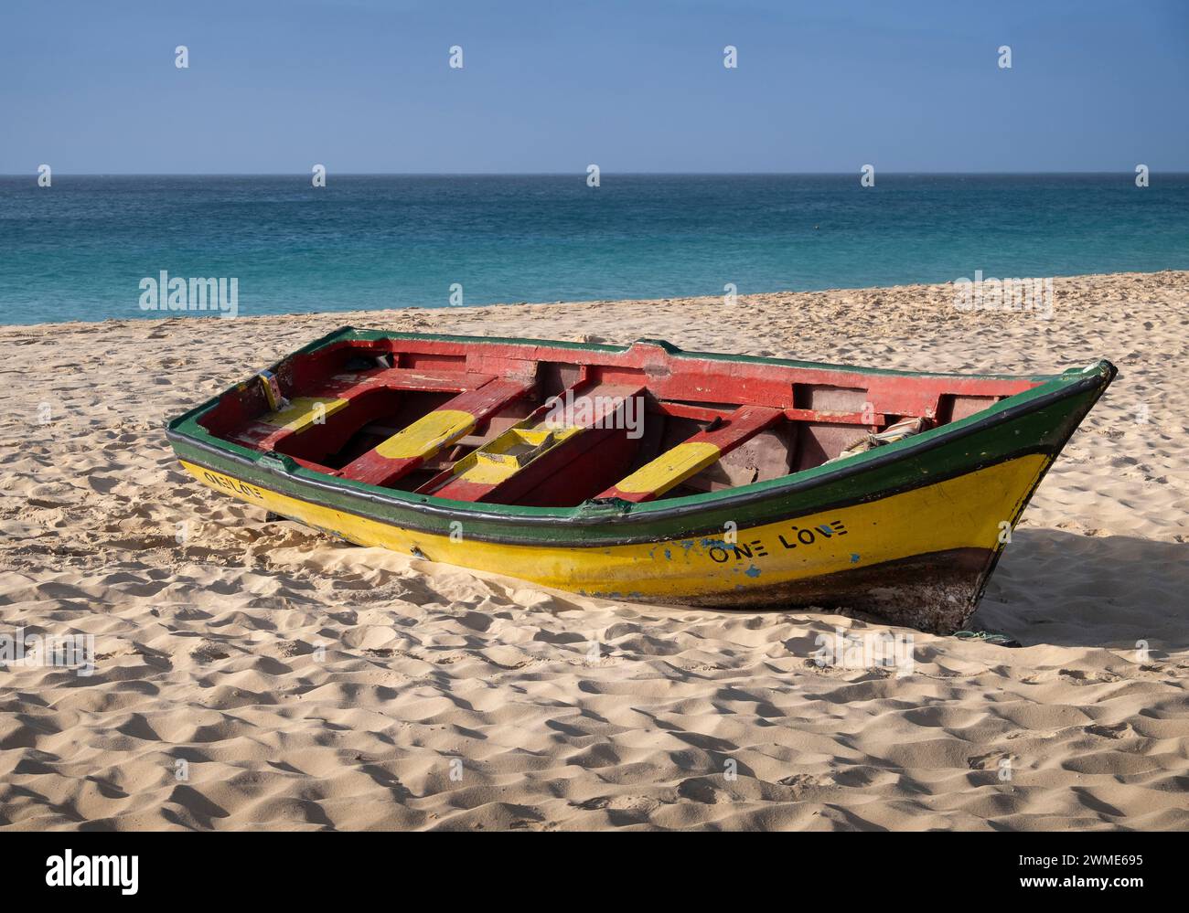 Colourful Fishing Boat with One Love painted on the Hull, Praia de Santa Maria Beach, Santa Maria, Sal, Cape Verde Islands, Africa Stock Photo