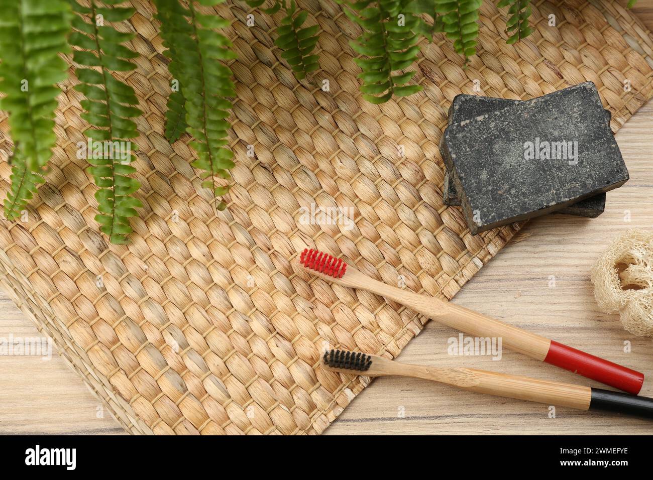 Flat lay composition with natural bamboo toothbrushes on wooden table Stock Photo