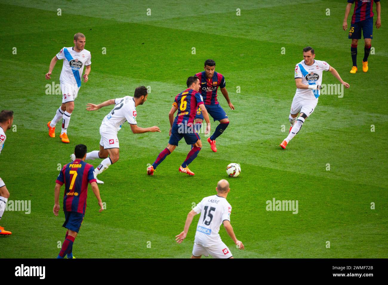 XAVI, FAREWELL GAME, BARCELONA FC, 2015: Xavi Hernandez of Barcelona makes a trademark tiki-taka pass. The final game of the La Liga 2014-15 season in Spain between Barcelona FC and Deportivo de La Coruna at Camp Nou, Barcelona on May 23 2015. The Game finished 2-2. Barcelona celebrated winning the championship title and legend Xavi's final home game. Deportiva got the point they needed to avoid relegation. Photograph: Rob Watkins Stock Photo